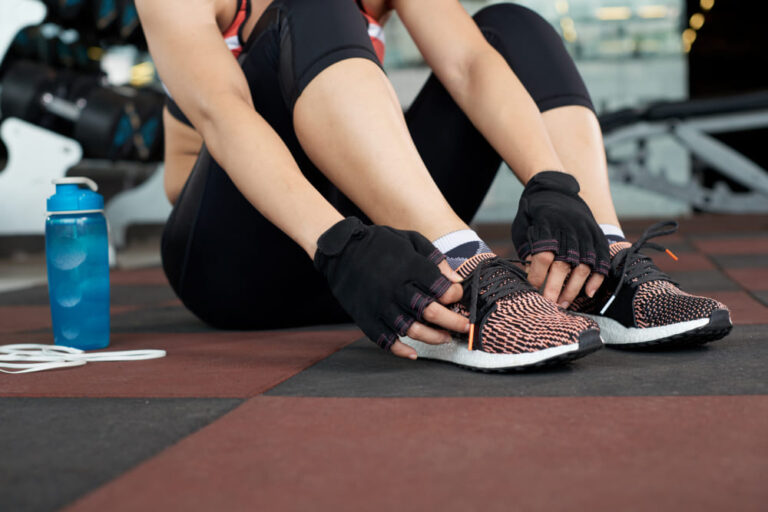 seccion-baja-mujer-irreconocible-ropa-deportiva-sentada-piso-gimnasio-atando-cordones-preparandose-entrenamiento (1)